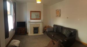 sala de estar con sofá y chimenea en 3 BedroomHouse For Corporate Stays in Kettering, en Kettering
