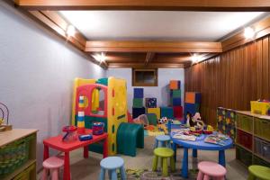 una sala de juegos con mesas y taburetes coloridos en Residence La Villa, en La Villa