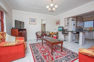 sala de estar con sofá rojo y mesa en Spacious Garden Cottage en Johannesburgo