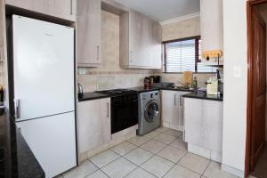 uma cozinha com um frigorífico e uma máquina de lavar louça em Spacious Garden Cottage em Joanesburgo