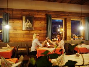 a group of three women sitting at a table in a restaurant at DAV-Haus (Alpenverein) in Obertauern
