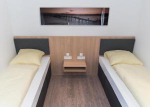 two beds in a small room with a table at Hotel Staffelseestraße in Munich