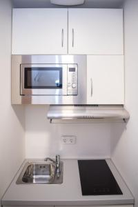 a kitchen with a sink and a microwave at Hotel Staffelseestraße in Munich