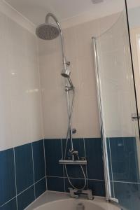 a shower head in a bathroom with a tub at No 10 Royal Apartments in North Berwick