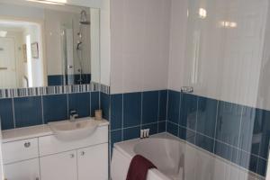 a bathroom with a tub and a sink and a mirror at No 10 Royal Apartments in North Berwick