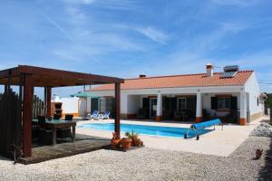 a villa with a swimming pool and a house at Casa Guna in Aljezur