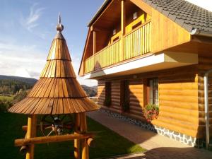 uma casa de madeira com uma roda à frente em Apartmány Lucie em Zdíkov