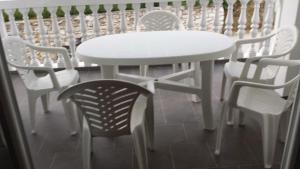 a white table and chairs and a white table and chairs at Apartmani kod Rade in Pakoštane