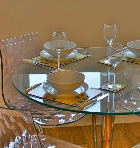 a glass table with wine glasses and plates on it at No 10 Royal Apartments in North Berwick +16 photos