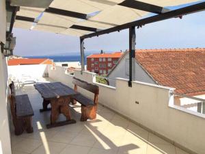 een patio met een houten tafel en een parasol bij Apartments Milas in Trogir