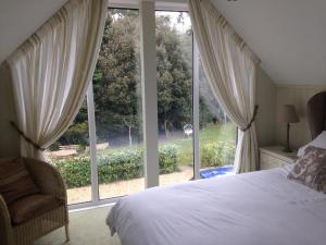 a bedroom with a bed and a large window at Squirrel in Southwold