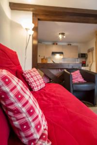 オットロットにあるGîtes de Charme Chez Christineの赤いベッド(枕付)が備わる客室です。