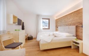 サン・ヴィジリオ・ディ・マレッベにあるLiving Natureの白いベッドと木製の壁が備わるベッドルーム1室が備わります。