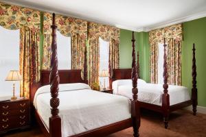 サバンナにあるプランターズ イン オン レイノルズ スクエアの緑の壁と窓が特徴のベッドルーム1室(ベッド2台付)