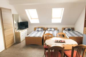 Schlafsaal mit 3 Betten und einem Tisch in der Unterkunft Apartment and rooms Maraton in Kranjska Gora