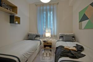 zwei Betten in einem kleinen Zimmer mit Fenster in der Unterkunft Le Terrazze sul Cortile in Salerno