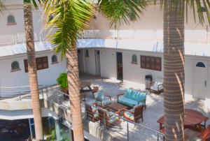 einen Balkon mit Palmen und Stühlen in der Unterkunft Hotel Rio Malecon in Puerto Vallarta
