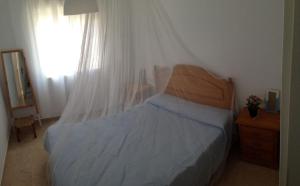 - une chambre avec un lit doté d'une tête de lit en bois et d'une fenêtre dans l'établissement Casa en playa Oliva y MET, à Oliva