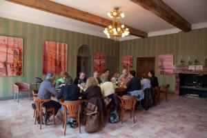 un grupo de personas sentadas en mesas en una habitación en Logis Hotel - Restaurant La Marbrerie, en Caunes-Minervois