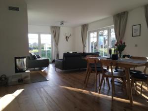 una sala de estar con una mesa y un sofá en Schwedenvilla Estelle, en Dörphof