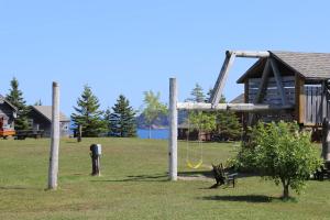 a playground in a park with a swing at Chalets Nature Océan in Perce