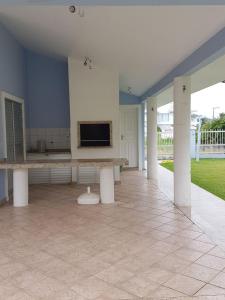 uma ampla sala de estar com paredes azuis e piso em azulejo em Casa de praia em Palmas-SC a 40 metros do mar em Governador Celso Ramos