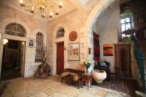 - un salon avec une table et un lustre dans l'établissement Jerusalem Hotel, à Jérusalem