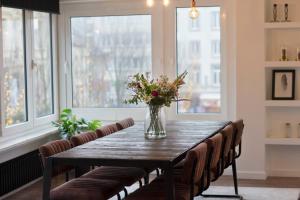 a dining room table with chairs and a vase of flowers at #Kaaistraat2 in Ostend