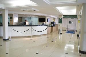 a hospital lobby with a woman sitting at a counter at Jandaia Turismo Hotel in Santana do Livramento