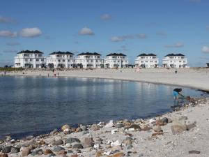 une personne jouant dans l'eau à la plage dans l'établissement Komfort-Ferienwohnung Wellenbrecher by Meer-Ferienwohnungen, à Olpenitz
