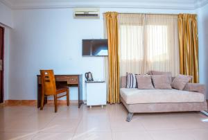 - un salon avec un canapé et un bureau dans l'établissement Le Feto, à Dakar