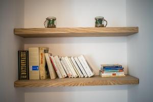 un montón de libros sentados en una estantería de madera en Au jardin des plantes en Dijon