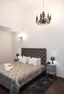 a bedroom with a large bed and a chandelier at Hotel " BOUTIQUE " in Uzhhorod