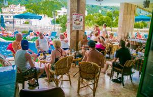 een groep mensen aan een tafel bij een zwembad bij Ozlem 2 Apart Hotel in Marmaris