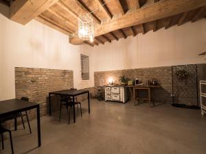 Großes Zimmer mit 2 Tischen und einer Küche in der Unterkunft Zucchero sui Baffi- Food Lovers B&B in Mantua