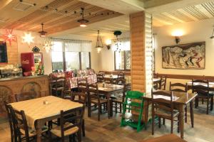 a restaurant with tables and chairs in a room at Apartment and rooms Maraton in Kranjska Gora