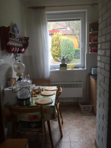 eine Küche mit einem Tisch und einem Fenster in der Unterkunft Ubytovanie v sukromi in Dolní Bzince