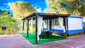 a blue and white shed with a table and chairs at Bungalows Rurales in Córdoba