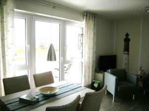 a dining room with a table and chairs and a large window at Strandgut in Horumersiel