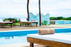 un asciugamano è seduto su un letto accanto alla piscina di Villa Mia Boutique a Los Órganos