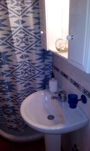 Un baño con lavabo y cortina de ducha azul y blanca. en Estudio Plaza San Sebastián, en Santa Cruz de la Palma 38 fotos más