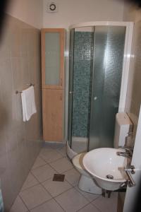 e bagno con servizi igienici, lavandino e doccia. di Apartment Arba 3 s bazenom i parkingom a Rab