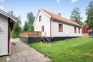 una casa bianca con un portico accanto a un cortile di Ferienhaus am Mycklaflon a Eksjö