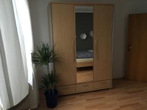 einem Holzschrank mit einem Bett mit zwei Pflanzen in der Unterkunft Ferienwohnung Sonnenfeld in Freilassing