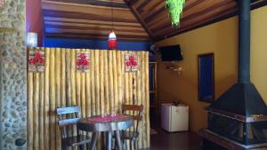 Pousada Casa Fazenda do Rio في فيسكوندي دي ماوا: غرفة طعام مع طاولة وكراسي وموقد