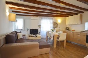 a living room with a couch and a table and a kitchen at Apartment Eleni in Rovinj