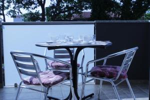 a table and two chairs with glasses on it at Apartments Barbic in Medulin