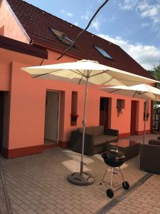 eine Terrasse mit einem Sonnenschirm, einem Stuhl und einem Grill in der Unterkunft Apartman Smolnicka Huta 211 in Smolnícka Huta