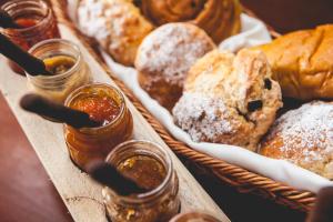 a basket of different types of bread and honey at Palmeiras Guest House Maputo in Maputo