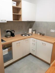 a kitchen with white cabinets and a sink at Apartamenty Jesionowa in Wrocław